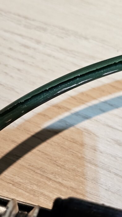 Sliten, grön kamrem med sprickor längs kanten ligger på en ljus träyta, del av ett forumdiskussionsämne om rotorstop.