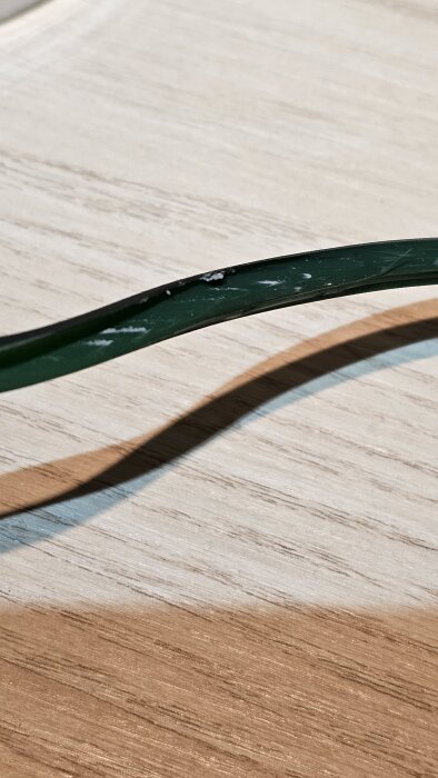 Sliten rem på ett skrivbord med tecken på skador.