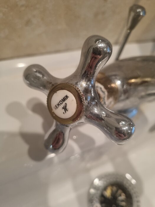 Kromad kranhandtag med texten "SEKOMIX" i närbild.