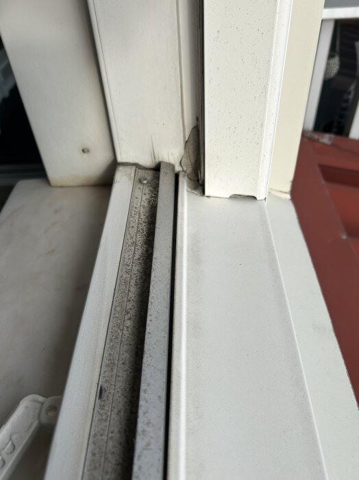 Bild av ett fönsterhörn med tecken på vattenskador och oregelbunden isolering, potentiellt orsakad av bristande tätning vid regn.