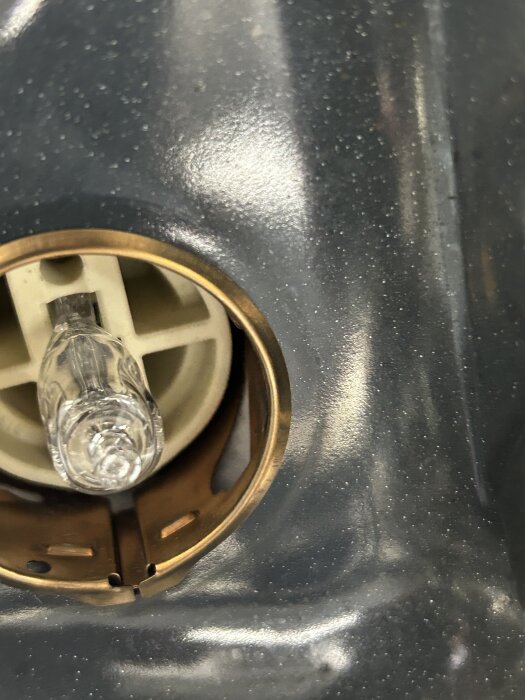 Glödlampa i IKEAs ugn, delvis utdragen från sockeln med synliga fästen, användaren undrar om lampan ska dras ut eller vridas för att lossna.