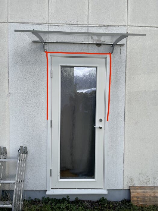 Dörr med överhäng och rödfärgad markering runt ramen för att indikera behov av latexfog för att stoppa vattenträngning.