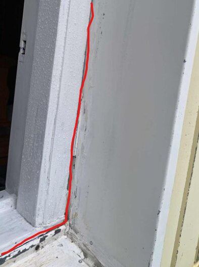 En fönsterkarm med synliga sprickor och ett rött streck markerar potentiella inläckagevägar.