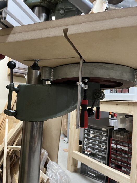 Borrmaskin med borrbord fäst under i träverkstad.