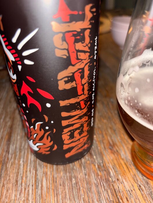 Berserker Autumn Red Ale burk på träbord, intill ett halvtomt glas öl.