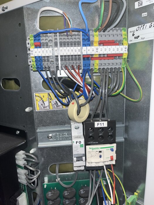 Inre del av en Thermia Diplomat Optimum G3 med elektriska kopplingar och motorskydd, kablar synliga för felsökning av teknisk problematik.