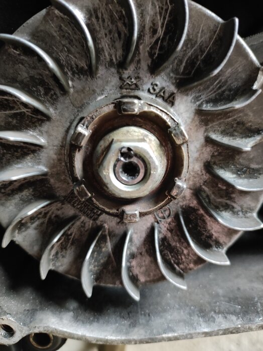 Närbild av en remskiva med lös mutter, fixad med borra och gängning, samt avbruten gängtapp och svets för att låsa fast på en moped.