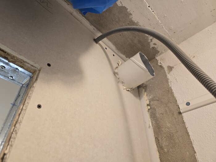 Flexrör och ventilationskanal installerade genom OSB och gips, med borrade hål för ventilation i byggprojekt.