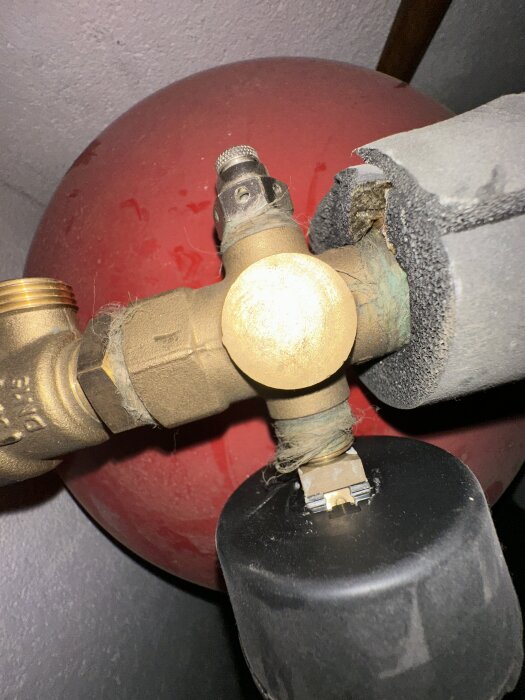 Röd expansionstank med ventil och isolerad rördel syns i närbild, del av Nibe Fighter 1225 värmepump.