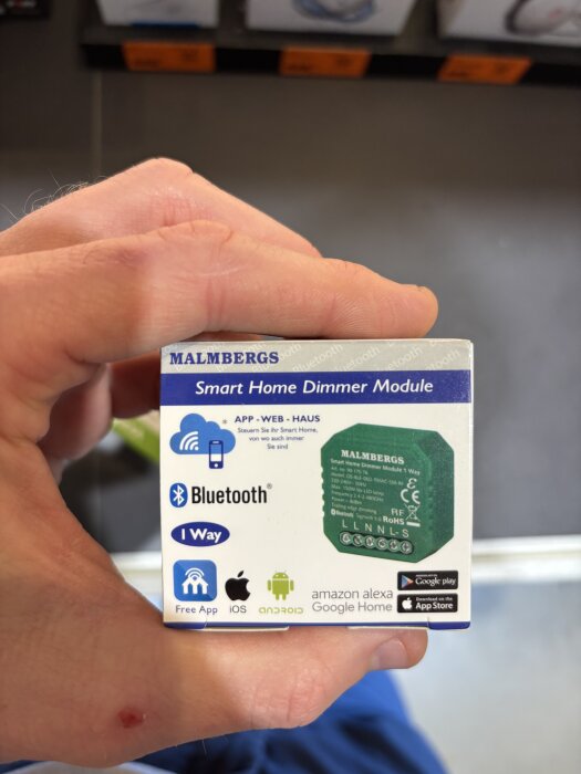 Förpackning av Malmbergs smart hem dimmermodul med Bluetooth och appar för iOS och Android.