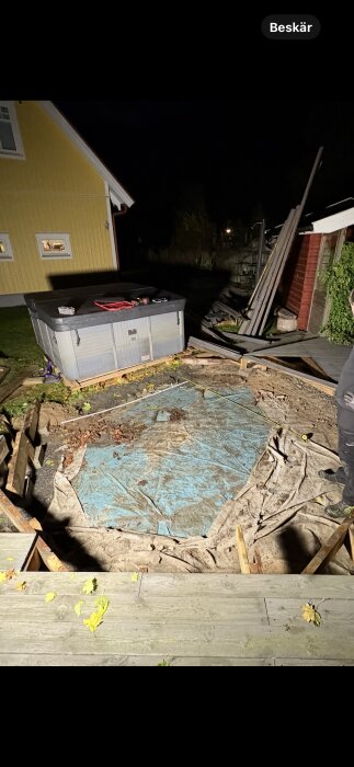 Spabad under natthimmel på plattform. Grus och fiberduk förberett som underlag, omgiven av träplankor.