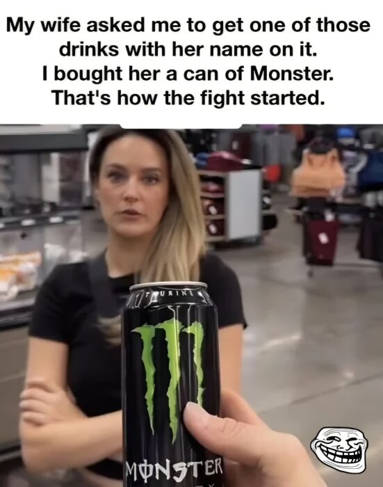 Man håller en Monster-energidryck i affär, framför en kvinna med armarna i kors och en text ovan som beskriver en humoristisk situation.