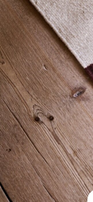 Mörkare brädgolv med tydliga träådringar.