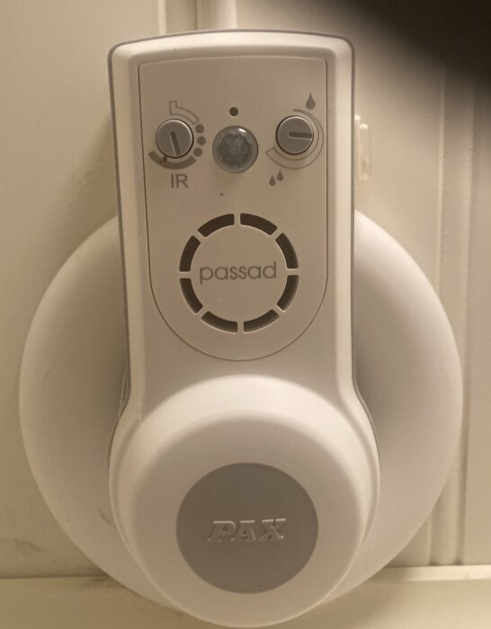 Pax-fläkt med justeringsknappar för IR-sensor och fukt, monterad på vägg.