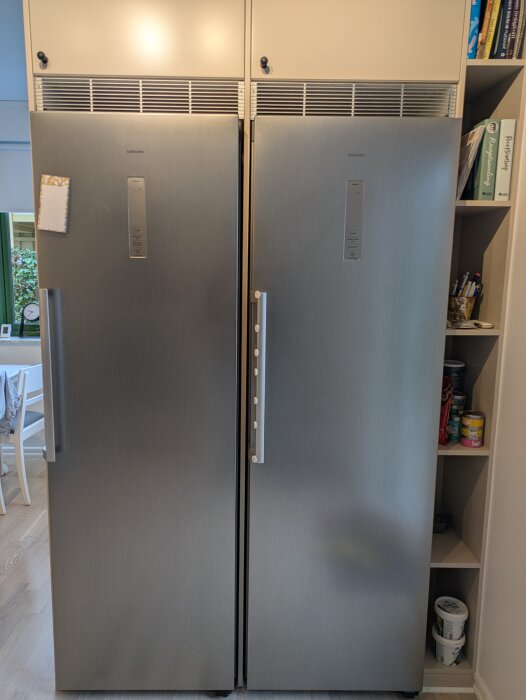 Kyl och frys sida vid sida med kylskåpsdörr som slår i frysens handtag, justerad med möbeltass. Grön pil visar läge för 90-gradersstopp.