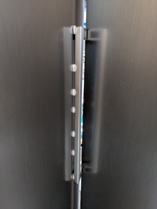 Kylskåpsdörr och fryshandtag med möbeltassar, grön pil visar gap för 90-gradersstopp.