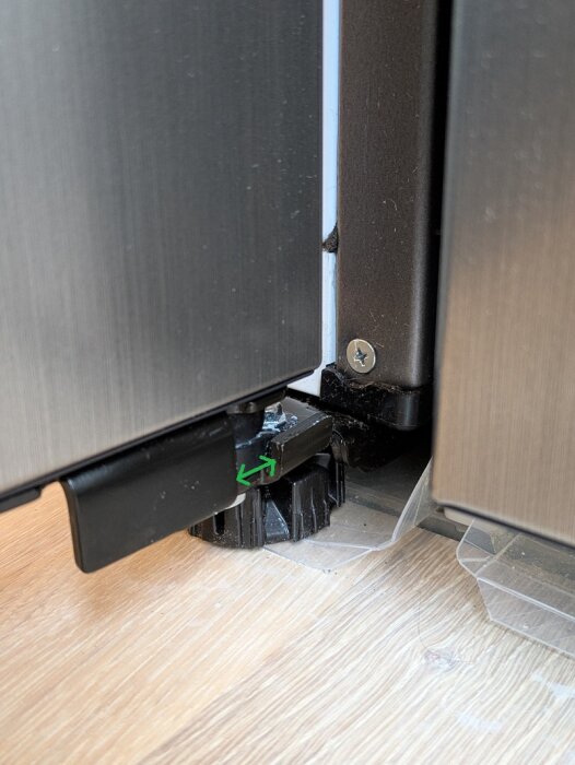 Kylskåpsdörr slår i fryshandtag. "Stop" monterat under dörren, med grön pil som visar gap där 90-graders stop behövs för bättre begränsning.