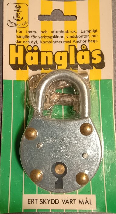 Gammaldags hänglås från Eskilstuna, märkt "Anchor Lås", på originalförpackning med gul och grön design.