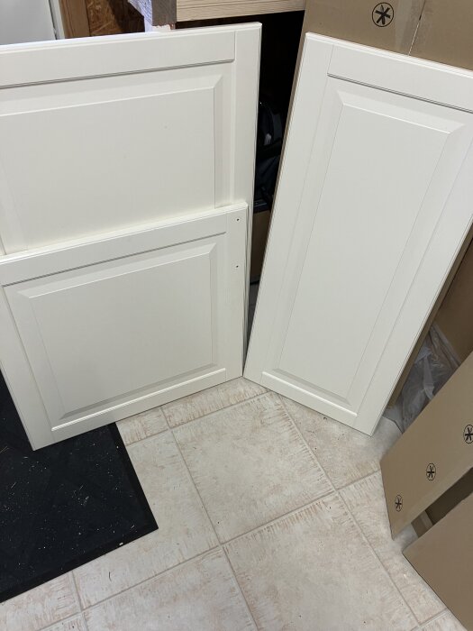 Vita köksluckor från Faktum-systemet placerade mot en ljus klinkergolv i ett renoveringsprojekt.