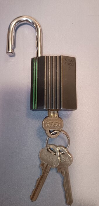 Öppet Assa Ruko hänglås med tre nycklar på vit bakgrund.