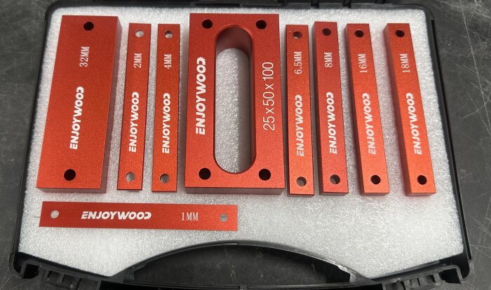 Rött plastetui innehållande olika storlekar av metallbitar med märkningen "ENJOYWOOD".