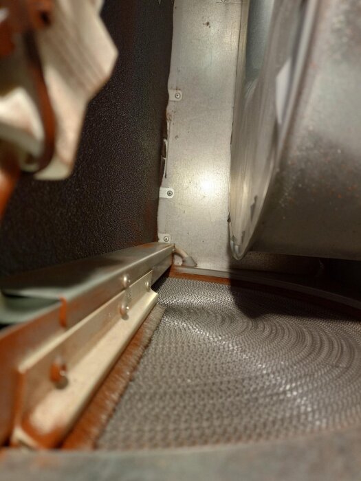 Luftventilation med rostfri rotor och detaljer, synlig på nära håll i ett aggregat. Möjliga spår av rött pulver kan ses på metallytorna.