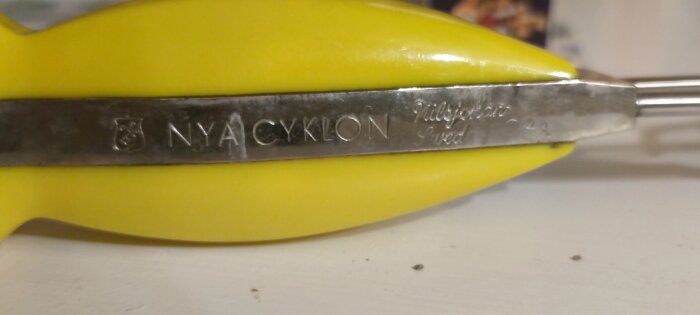 Gul vintage handvisp med texten "NYA CYKLON, Tillverkad i Sverige" ingraverad på metallen, inköpt på loppis.