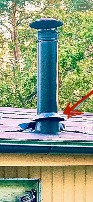 Grön stos monterad på isolerad skorsten med glipa, utan regnkrage, vilket kan orsaka vattenläckage i stuga.