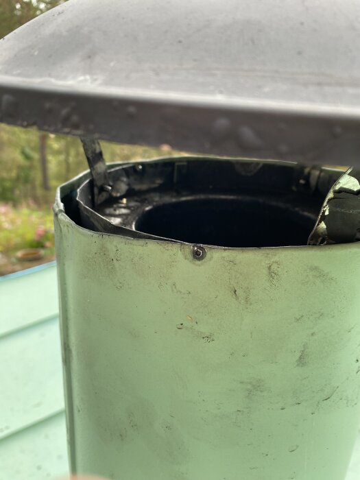 Grön stos monterad över en isolerad skorsten utan regnkrage; synlig glipa mellan stos och skorsten.