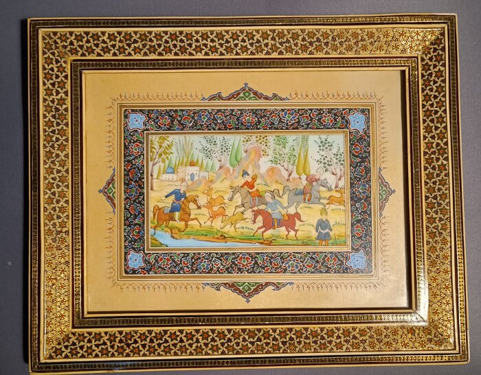 En elegant målning med hästridande personer, omgiven av gulddekorationer och intrikata geometriska mönster i traditionell iransk stil.