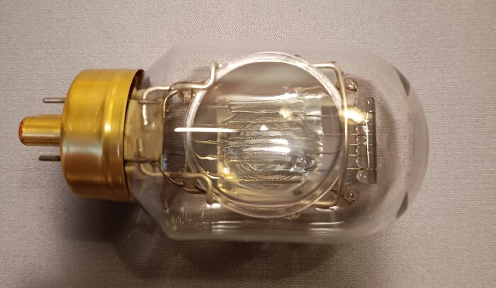 Äldre projektorlampa med komplex konstruktion och mässingsdetaljer. Ger ett kraftigt koncentrerat ljus.