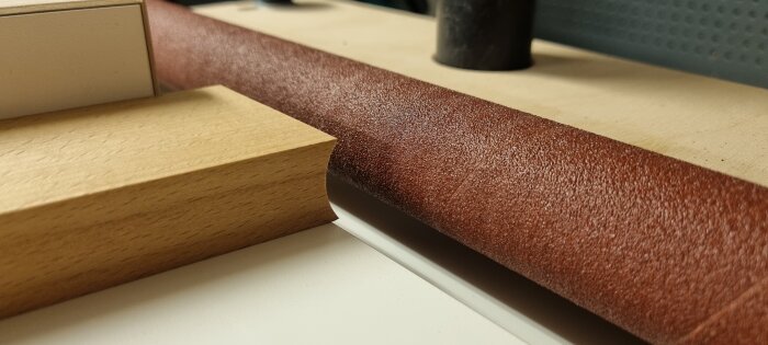 Närbild av sliprullar gjorda av en svarv, placerade på en träyta, med verktyg och material i närheten.