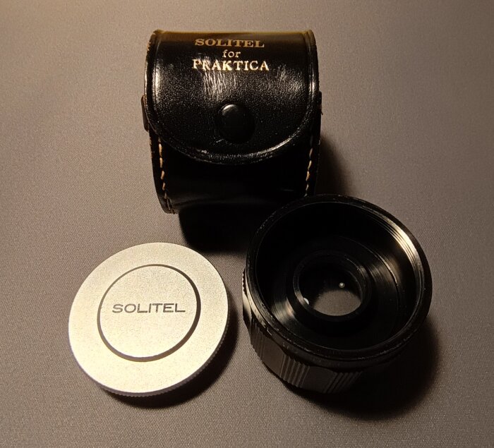 Telekonverter Solitel för Praktica-kamera med läderväska och linslock.
