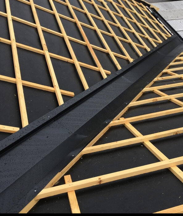 Tak med träreglar och svart underlag, visar en Tänndalens konstruktion där det varnas för framtida läckage och röta.