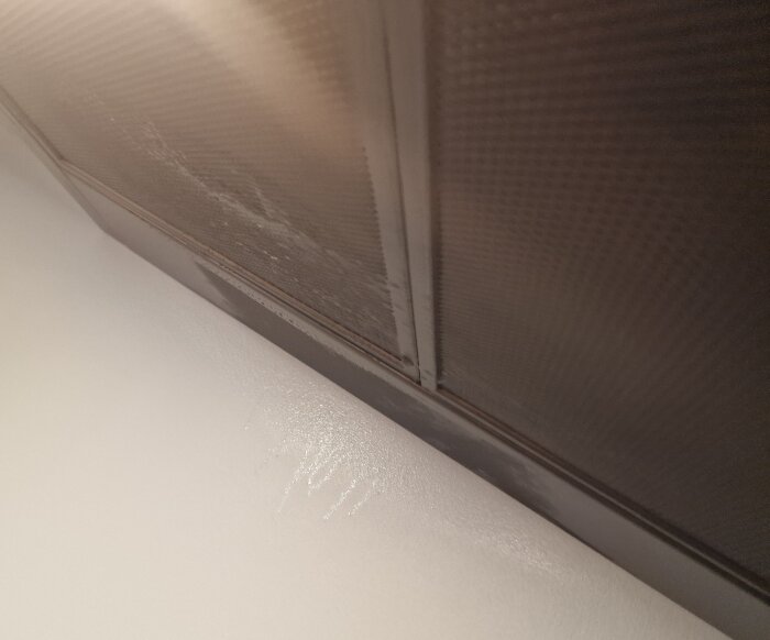 Fläktfilter med droppande vatten och fuktig vägg i köket, indikerar problem med ventilationssystemet.