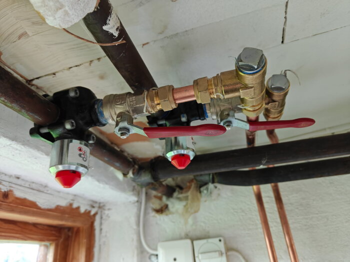 Rörledningar med ventiler och kopplingar i ett tak, potentiellt problem med värmeöverföring till pumpen.