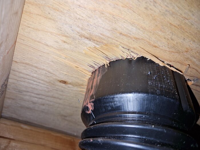 Plaströr genom plywood med flisor runt öppningen, del av takinstallation.