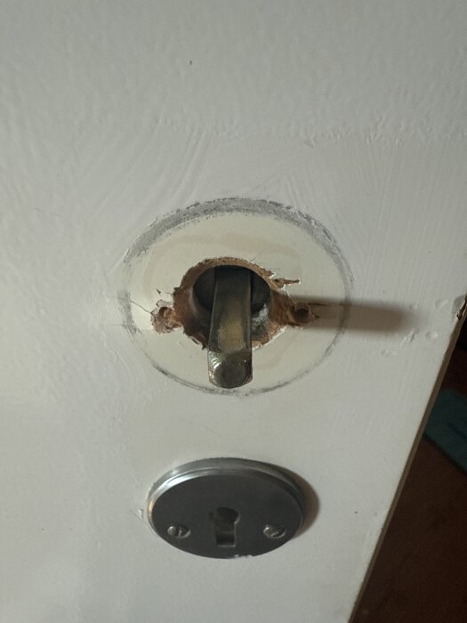 Dörr med skadat handtag där trä runt hålet är flisat; frågeställning om reparation med epoxispackel.