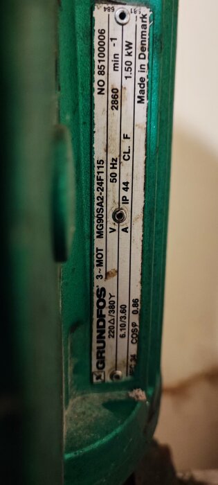 Etikett på en Grundfos-pump med specifikationer som serienummer, hertz, kilowatt, tillverkad i Danmark.