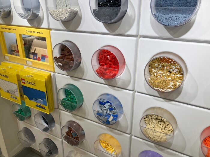 Hylla i Legobutik med lådor fyllda med lösa Legobitar i olika färger och paket med Lego Classic.