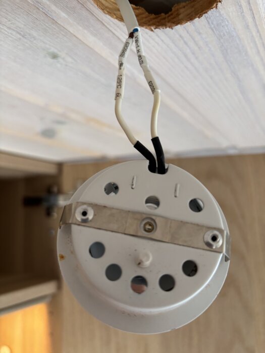 Gamla halogenspottar med synliga kablar hänger från taket. Inga plintar ses på bild.