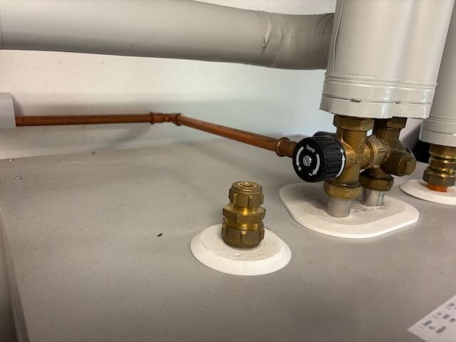 Dräneringsrör och ventiler på en varmvattenberedare, kopplade till en bergvärmepump.