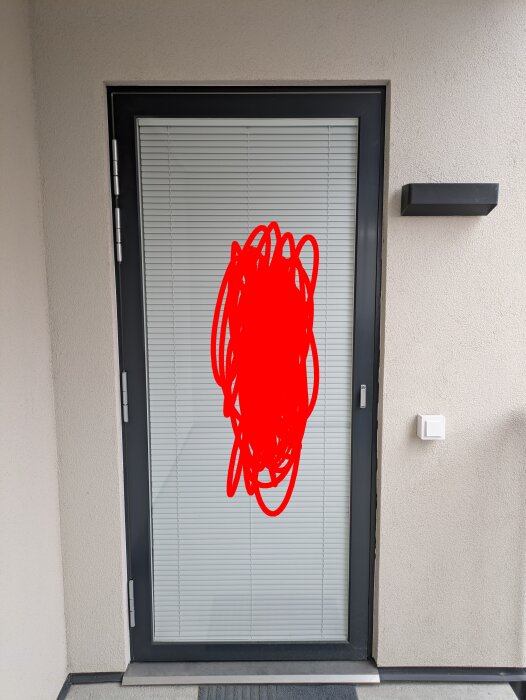 Dörr med glasruta och persienner sedd utifrån, med en röd fläck markerad som reflektion.