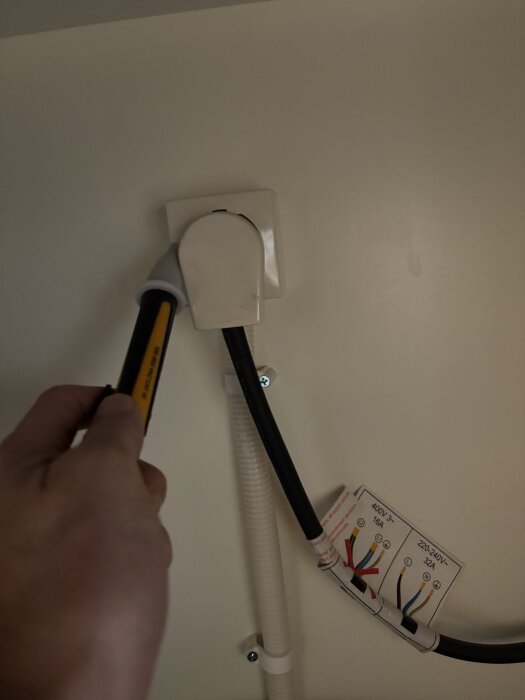 En faspenna testas vid en spisanslutning för att kontrollera vilka sidor som har spänning.