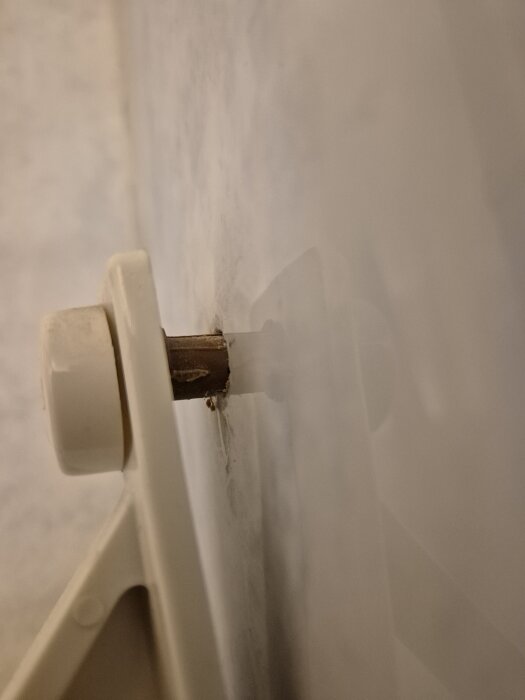 Skruvinställning i badrumsvägg med eventuell vattenskada; användaren undrar om det krävs professionell hjälp för tätning.