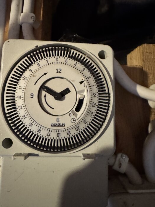 Grässlin tidur med inställningar för skymningsrelä, visande tid och numrerade markeringar. Klockan står på cirka kl16.