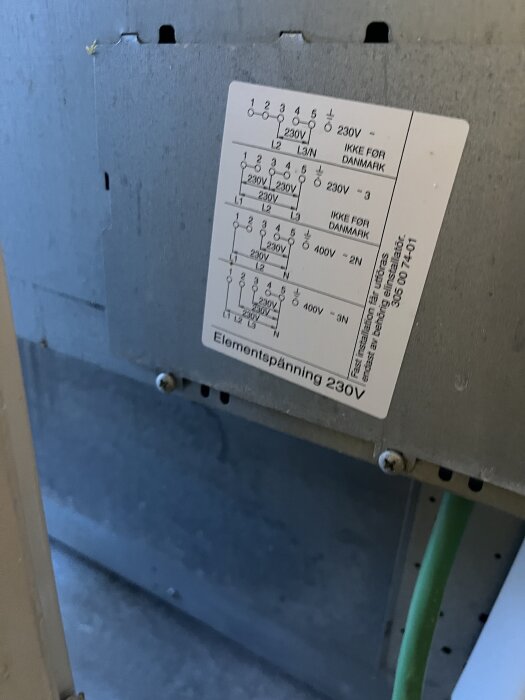 Närbild på etikett med elektriska anslutningsscheman för spis, bl.a. "230V 3~" och "400V 2N", med texten "IKKE FOR DANMARK" på en metallpanel.