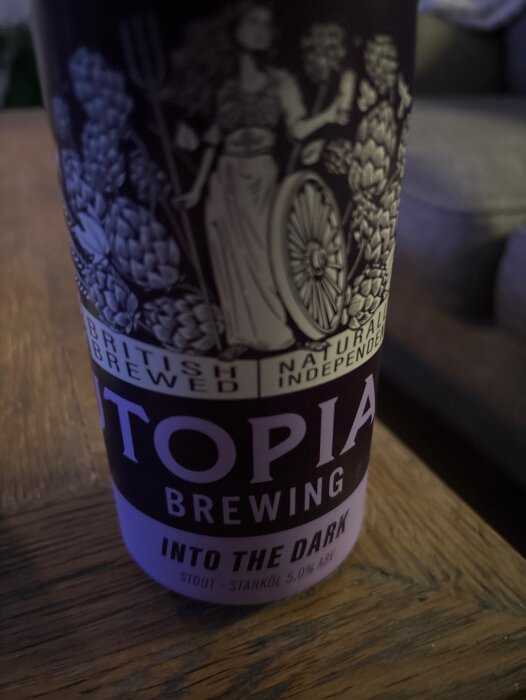 Flaska med etikett "Utopia Brewing Into the Dark Stout", avbildar humle och kvinna med ett hjul.