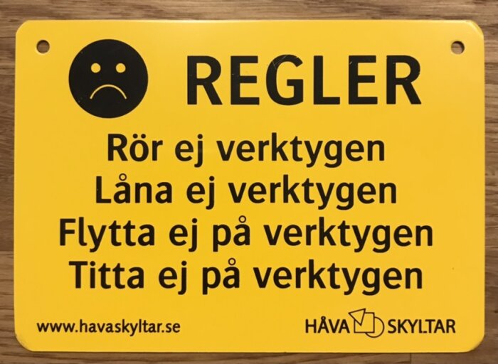 Skylt med regler och en ledsen smiley: "Rör ej verktygen, Låna ej verktygen, Flytta ej på verktygen, Titta ej på verktygen".