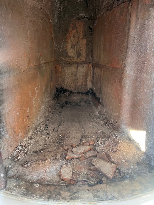 Sprucket lerlager i botten av kakelugn efter eldning med fyra vedklabbar.